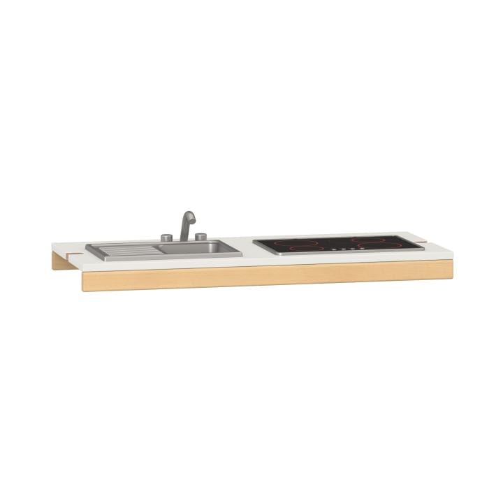 Eine minimalistische Küchenarbeitsplatte mit eingebauter Edelstahlspüle und Wasserhahn auf der linken Seite und einem schwarzen Elektroherd auf der rechten Seite, der auf einem Sockel aus hellem Holz und Weiß steht.