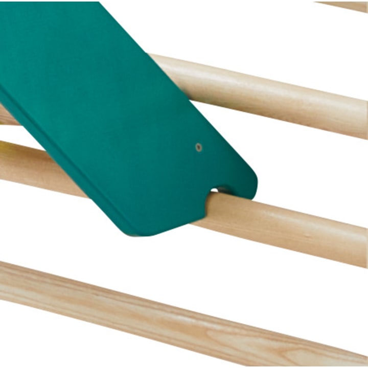 Eine Nahaufnahme einer grünen Kunststoffrutsche, die auf hellen Holzstäben steht, wahrscheinlich Teil eines Spielplatzes oder einer Indoor-Spielanlage.