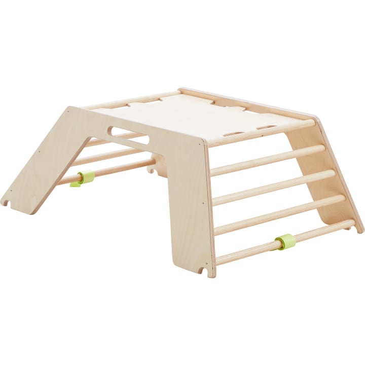 Eine hölzerne Kletterstruktur mit einer flachen Oberseite, Leitersprossen auf beiden Seiten und zwei grünen Sicherheitssperren an den unteren Sprossen. Die Struktur befindet sich auf einem weißen Hintergrund.