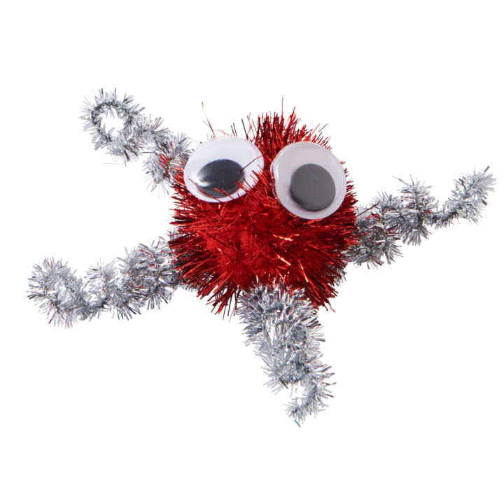 Eine Bastelfigur aus einem roten Lametta-Bommel mit zwei großen Kulleraugen und vier silbernen Lametta-Pfeifenputzern als Gliedmaßen vor einem weißen Hintergrund.