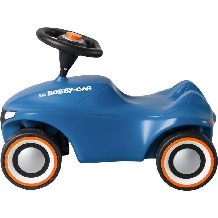 Ein blaues auffahrbares Spielzeugauto aus Kunststoff mit vier schwarz-weißen Rädern, einem orangefarbenen Knopf am Lenkrad und der Aufschrift BIG Bobby-Car an der Seite. Das Auto ist im Profil vor einem weißen Hintergrund abgebildet.