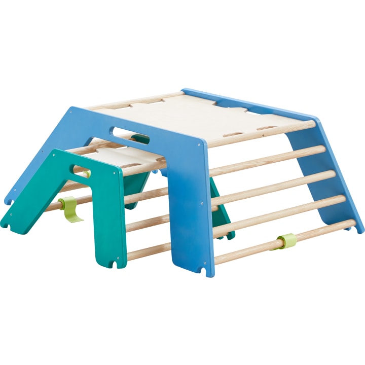 Ein hölzernes Klettergerüst mit blauen und grünen Seitenwänden und horizontalen Holzsprossen, das für Kinder zum Spielen oder Trainieren gedacht ist. Die Struktur ist auf einem weißen Hintergrund positioniert.