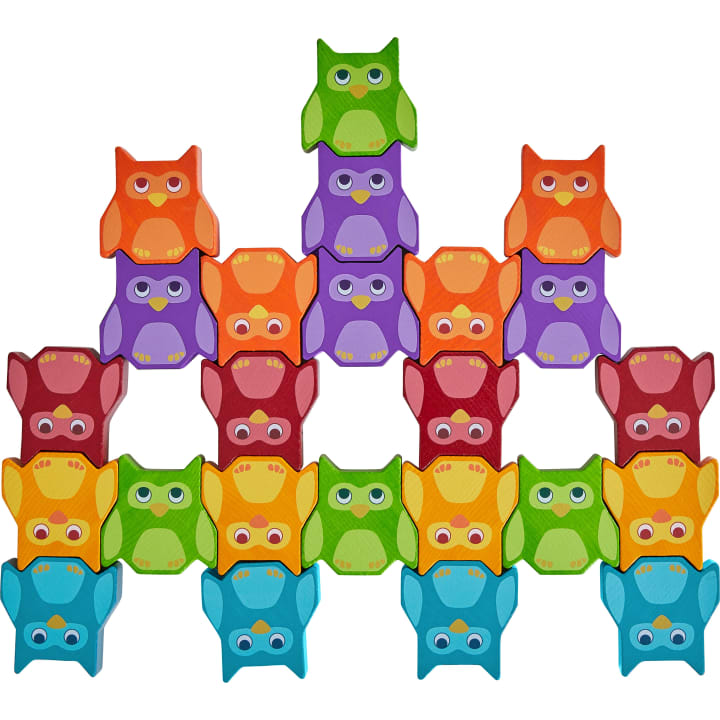 Eine Pyramide aus bunten hölzernen Eulenfiguren in Grün, Lila, Orange, Rot, Gelb und Blau, jede mit großen Augen und Flügeln, gestapelt auf einem weißen Hintergrund.
