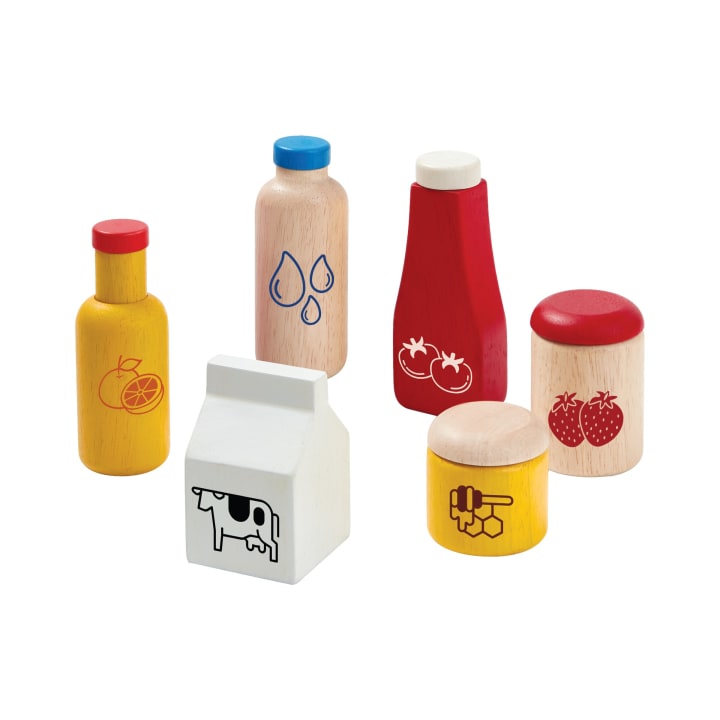 Ein Satz von sechs hölzernen Spielzeug-Lebensmittelbehältern, darunter Flaschen, Gläser und ein Karton, die jeweils mit einfachen Bildern von Obst, Milchprodukten, Wassertropfen, Tomaten und Honig bemalt sind.