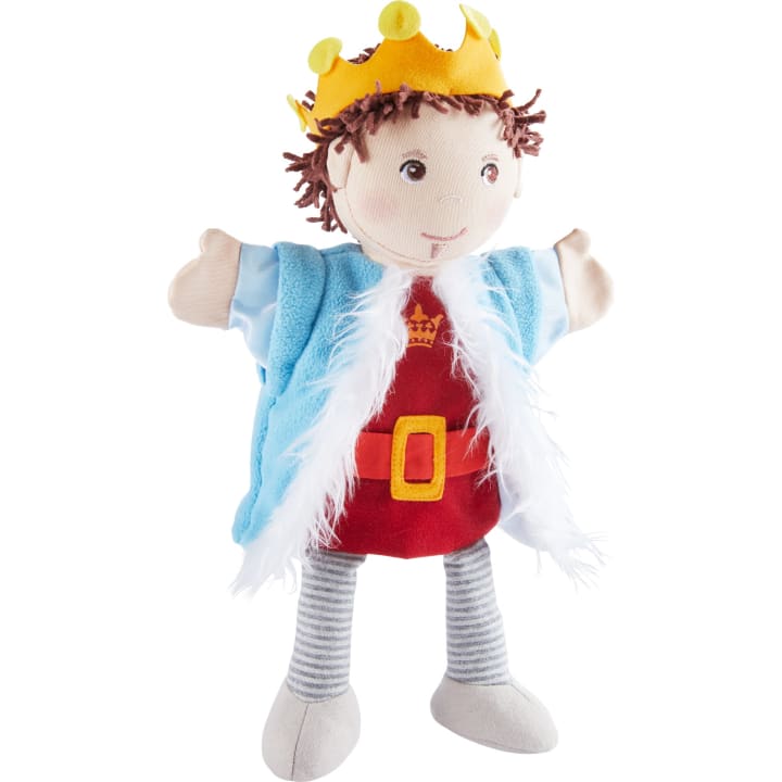 Eine Plüschpuppe als König mit gelber Krone, blauem Umhang mit weißer Borte, rotem Gewand mit goldenem Gürtel und grau gestreiften Beinen. Die Puppe hat braunes Haar und einen freundlichen Gesichtsausdruck.
