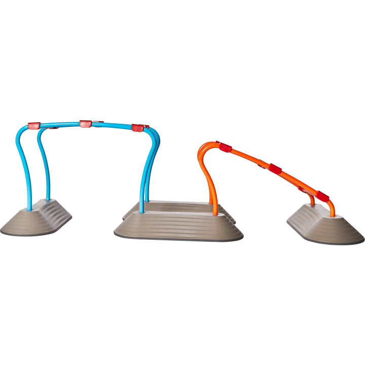 Drei Spielgeräte mit gebogenen Stangen in Blau und Orange sind an grauen, rechteckigen, leicht erhöhten Plattformen befestigt. Die blaue Struktur wölbt sich über zwei Plattformen, während die orangefarbene Struktur zum Boden hin abfällt.