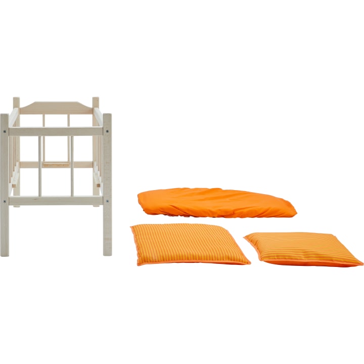 Ein kleines hölzernes Kinderbett wird neben drei orangefarbenen Bettwaren gezeigt: ein Kissen, eine Decke und eine Matratze, alles ordentlich auf einem weißen Hintergrund angeordnet.