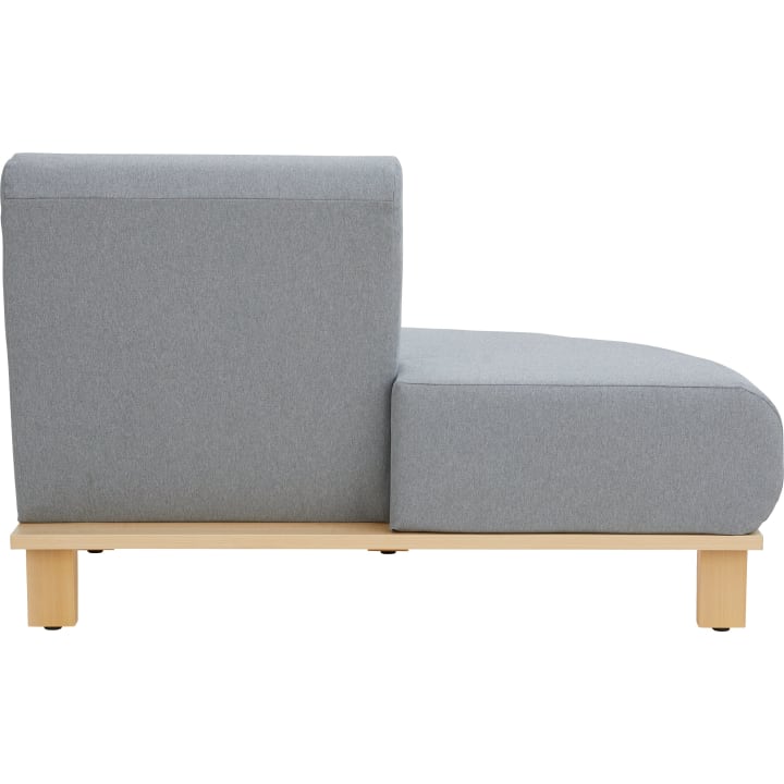 Eine moderne Chaiselongue ohne Armlehnen mit hellgrauer Polsterung und hellen Holzbeinen, dargestellt von der Seite vor einem weißen Hintergrund.