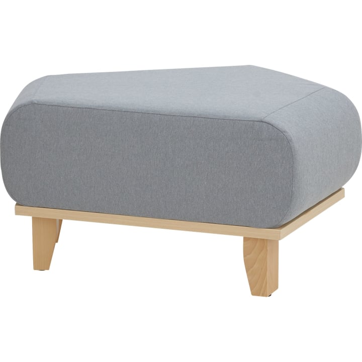 Ein moderner Hocker mit einem hellgrauen, abgerundeten, rechteckigen Kissen auf einem hellen Holzsockel mit vier abgewinkelten Beinen.