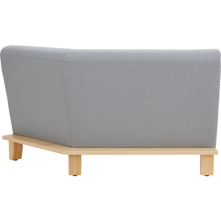 Ein grau gepolsterter Sessel mit hoher Rückenlehne und Seitenwänden, gestützt von einem hellen Holzsockel und vier Beinen, aus dem hinteren linken Winkel gezeigt.