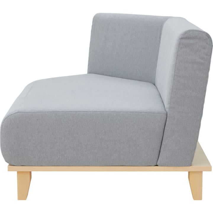 Seitenansicht eines modernen Sofas mit hellgrauer Polsterung, einem dick gepolsterten Sitz und einem Holzgestell mit kurzen Beinen. Die Rückenlehne und die Armlehne sind ebenfalls gepolstert und mit demselben Stoff bezogen.