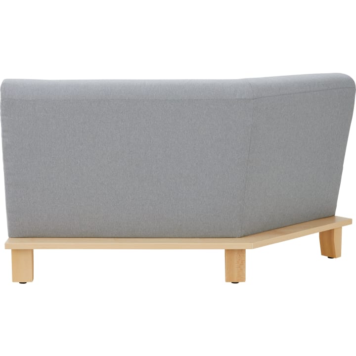 Ein hellgraues, gepolstertes Ecksofa mit Holzsockel und -beinen, das von hinten schräg vor einem weißen Hintergrund gezeigt wird.