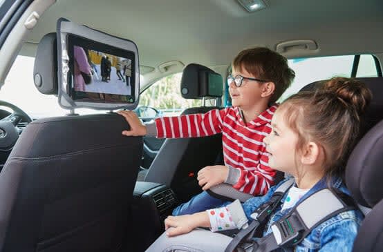 Kinder vor Tablets in Kopfstützen im Auto