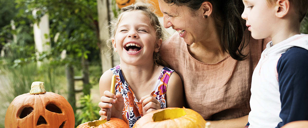Kürbis schnitzen: Spaß für die ganze Familie Mutter und Kinder höhlen einen Kürbis aus
