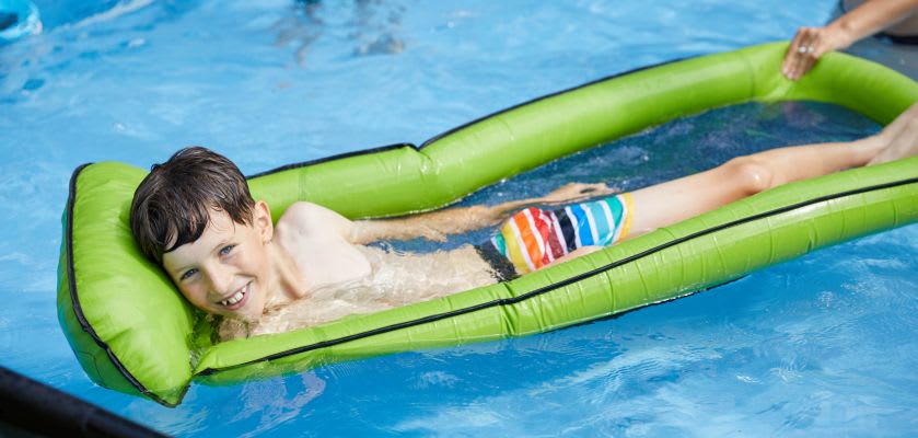 Kinder im Wasser: Junge mit Luftmatratze