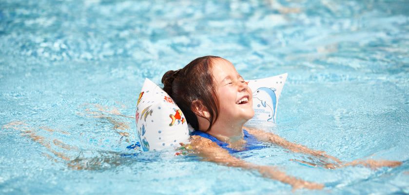 Schwimmen lernen: So sind eure Kinder noch sicherer im Wasser Kinder im Wasser: Mädchen mit Schwimmflügeln