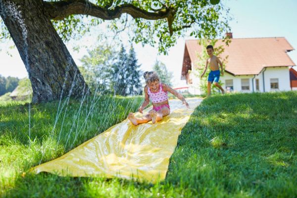 Kinder im Wasser: So gewöhnt ihr eure Kleinen an den Plansch-Spaß Kinder im Wasser: Wasserrutsche im Garten