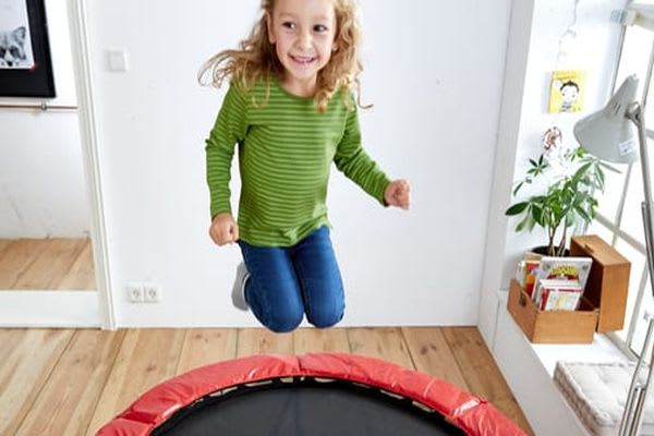 Sport mit Kindern: Mädchen springt auf Trampolin