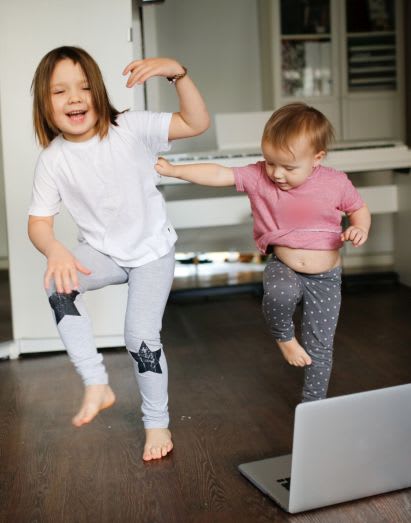 Sportübungen für Kinder: Geschwister beim Tanzen