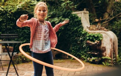 Sportübungen für Kinder: Mädchen mit Hula-Hoop
