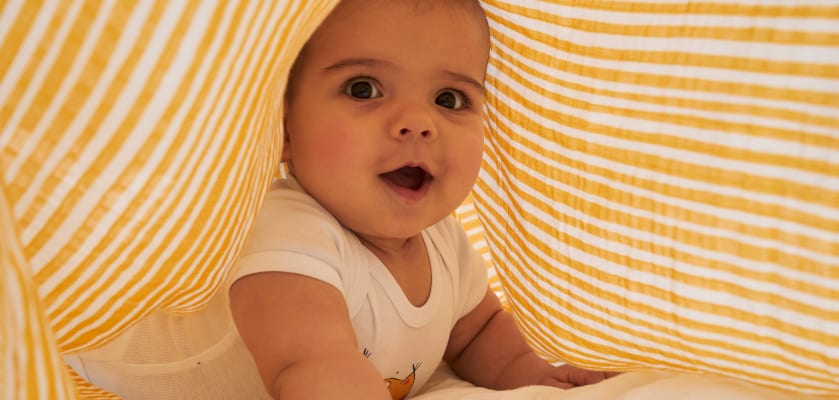 Babys im Sommer anziehen: Baby unter luftigem Musselin-Tuch