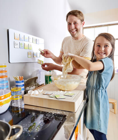 Backen mit Kindern: Gemeinsames Mischen von Zutaten Backen mit Kindern: Vater backt mit seiner Tochter