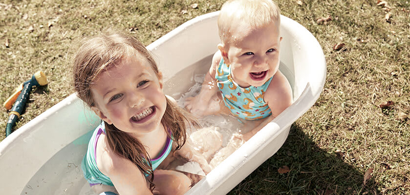 Wasserspiele mit Kindern: Zwei Kinder sitzen in einer Wasserwanne