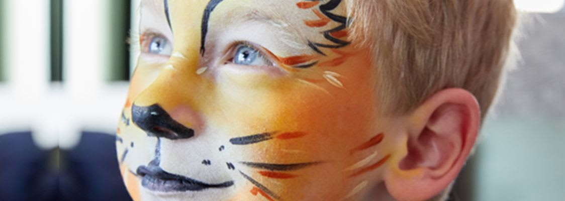 Kinderschminken zu Fasching: Junge mit geschminktem Löwen-Gesicht