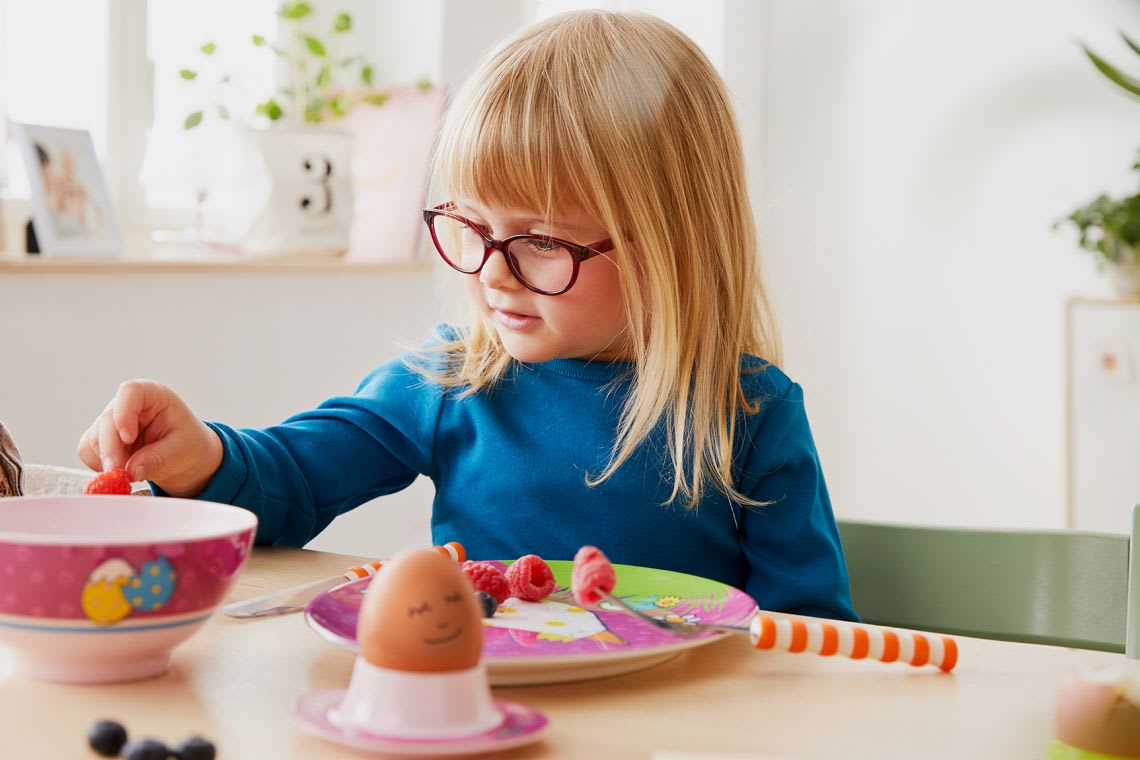 Alternativen zum Basteln mit Kindern für Ostern: Mädchen beim Osterfrühstück