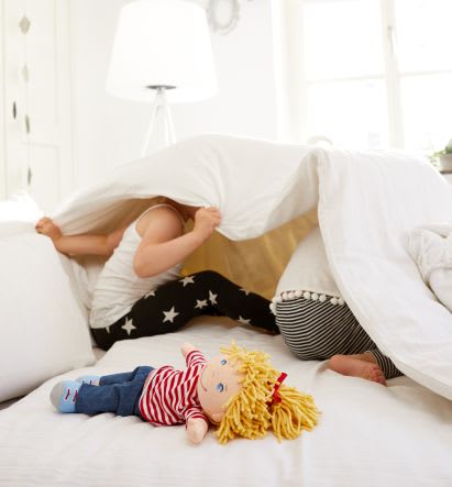 Familienspiel-Ideen: Präpositionen-Spiel Familienspiel-Ideen: Kinder spielen unter einer Decke