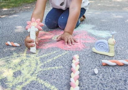 Gartenspiele: Mädchen malt mit Straßenmalkreide