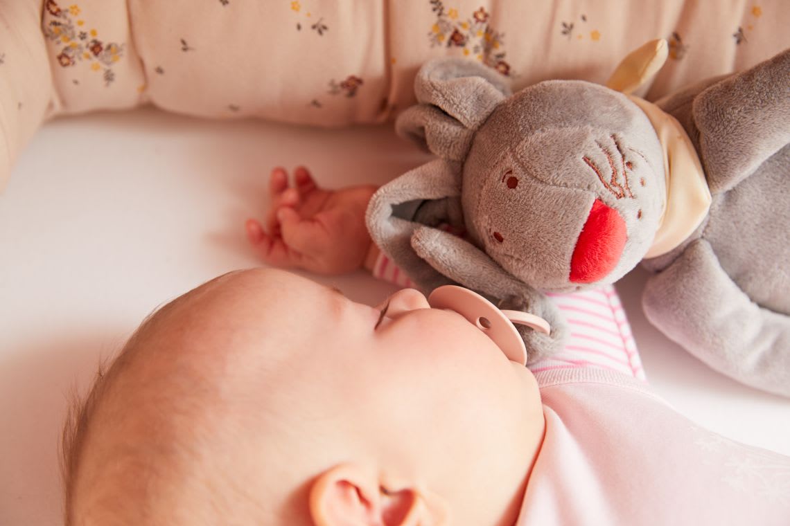 Kuscheltiere helfen Babys beim Einschlafen & Träumen Kuscheltiere zum Einschlafen: Baby schläft im Bettchen mit Schnullerhasen