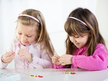 Muttertagsgeschenke basteln: Schönes Armband für Mama Muttertagsgeschenke basteln: Mädchen basteln gemeinsam Armbänder