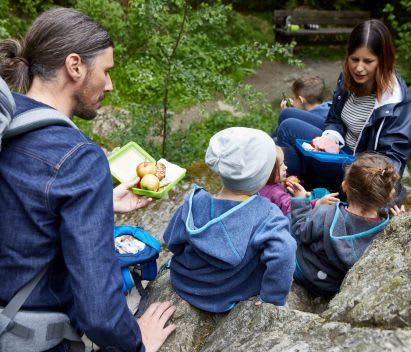 Picknick mit Kindern: bei Ausflügen oder Wandertouren besonders beliebt Familie macht beim Wandern ein Picknick mit Kindern