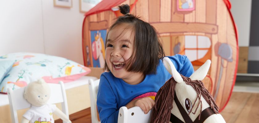 Spielen mit Kindern: Mädchen spielt im Kinderzimmer