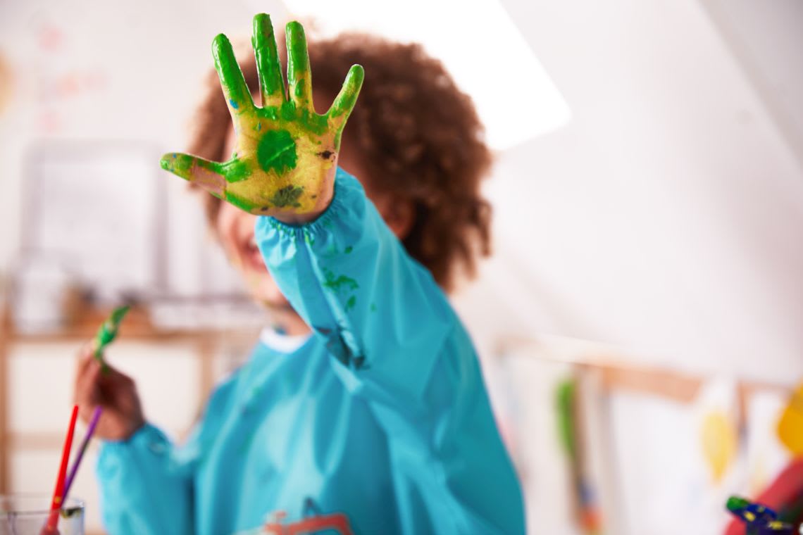 Alternative zu Ausflügen mit Kleinkind: Mädchen malt mit Farbe