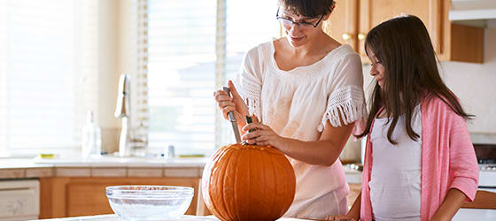 mother_and_daughter_having_fun_carving_pumpkin01.jpg