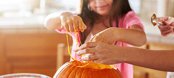 little_girl_with_slime_on_hands_from_pumpkin_to_make_jack_o_lantern_for_halloween.jpg