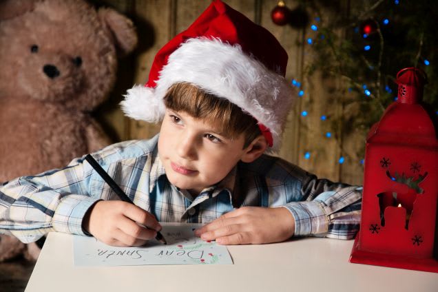Weihnachten mit Kindern: Junge schreibt Wunschzettel