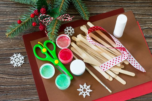 Weihnachtsbaumschmuck basteln: Eisstiele & weitere Materialien liegen auf einem Tisch bereit