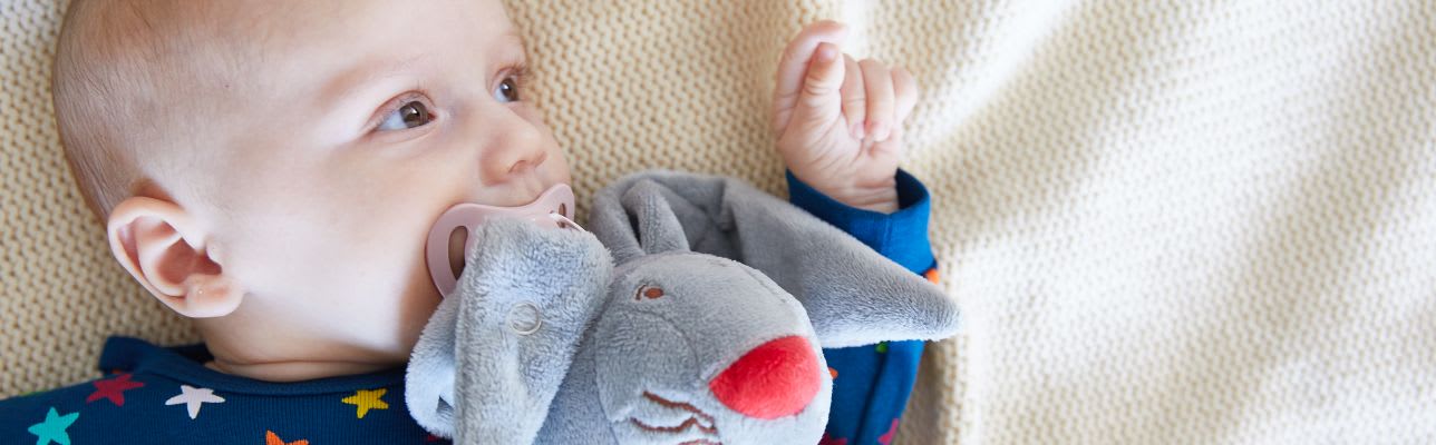 Erstausstattung Babys im Herbst: Kind mit Kuscheltier