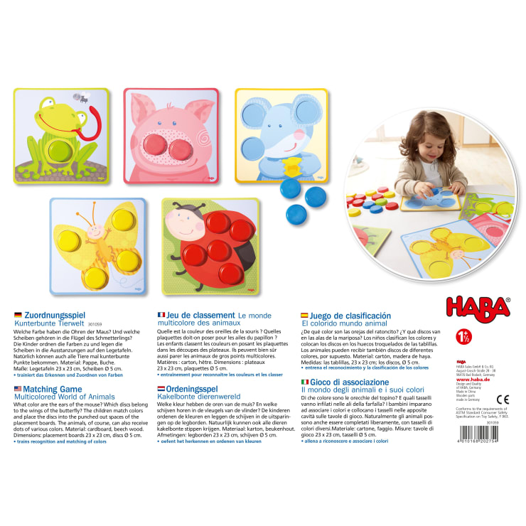 Ein passendes Spielset mit vier Spielbrettern mit Tiermotiven (Frosch, Schwein, Elefant, Marienkäfer), jeweils mit farbigen Kreisen, farbigen Plastikchips und einem kleinen Kind, das mit den Figuren an einem Tisch spielt. Das Branding von HABA ist sichtbar.