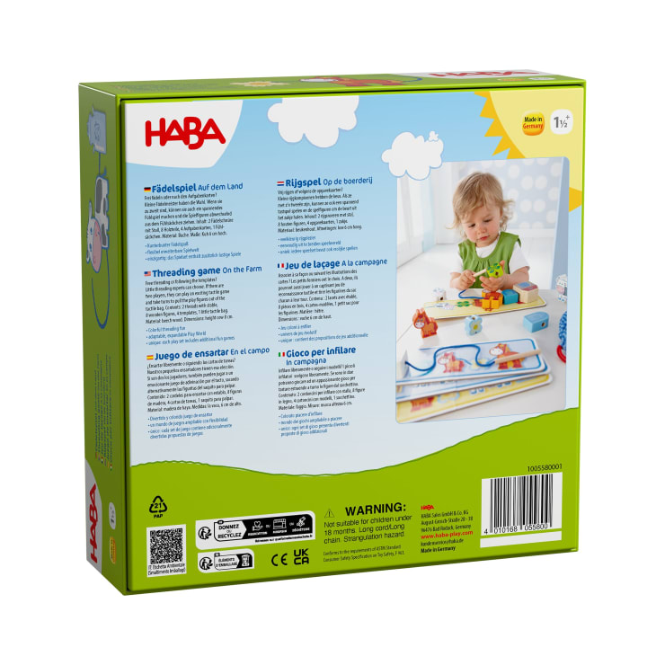 Die Rückseite einer HABA-Spielzeugkiste zeigt Produktinformationen in mehreren Sprachen, eine Altersangabe ab 18 Monaten, verschiedene Zertifizierungslogos und ein Foto eines Kleinkindes, das mit einem Fädelspiel auf dem Bauernhof spielt.