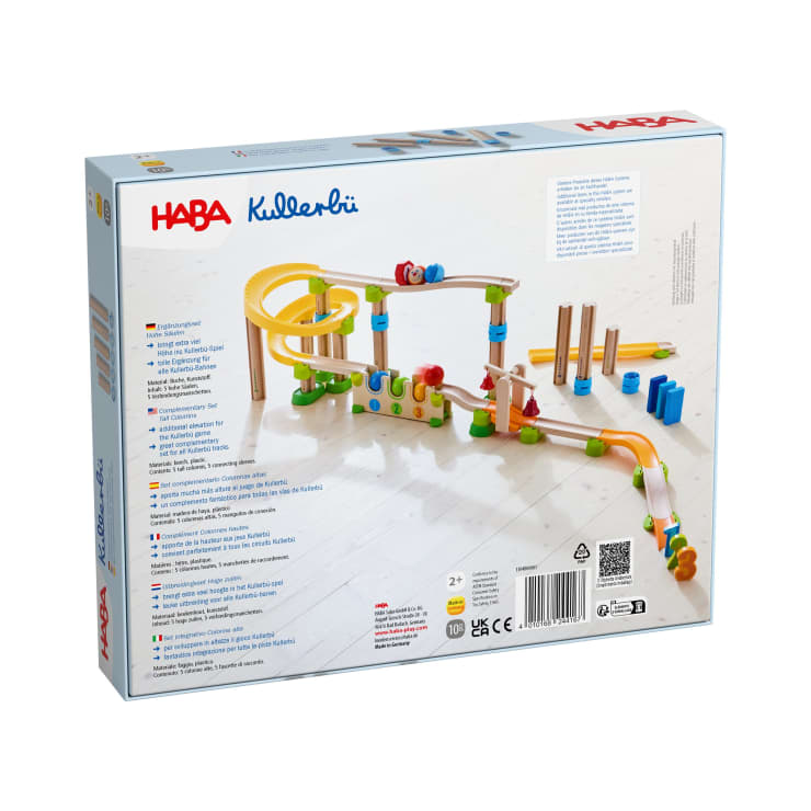 Ein Holzmurmelbahn-Baukasten mit gelben, grünen, blauen und natürlichen Holzteilen ist auf einem hellblauen Hintergrund aufgebaut. Auf der Schachtel sind das HABA Kullerbü-Logo und Produktdetails in mehreren Sprachen abgebildet.