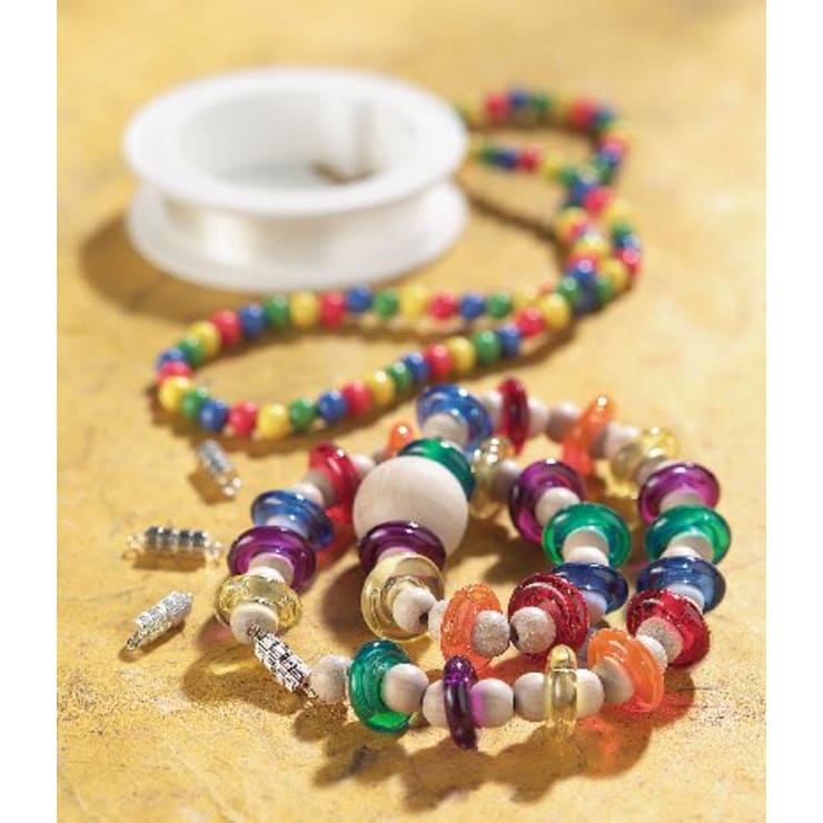 Bunter Perlenschmuck, darunter ein Armband und eine Halskette mit runden Perlen in verschiedenen Farben, ist auf einer gelben Fläche angeordnet. Eine Spule mit durchsichtiger Schnur und mehrere silberne Verschlüsse sind ebenfalls zu sehen.