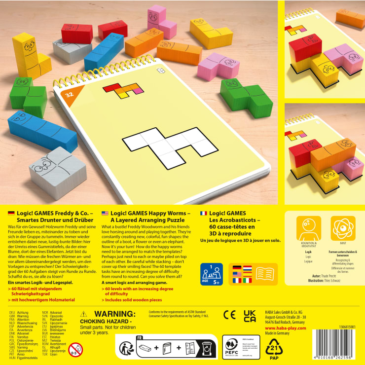Ein Puzzleset mit bunten, blockförmigen Teilen mit Gesichtern und einem spiralgebundenen Heft mit verschiedenen Rätselaufgaben. Mehrere Blöcke und Hefte sind auf einer Holzfläche angeordnet.