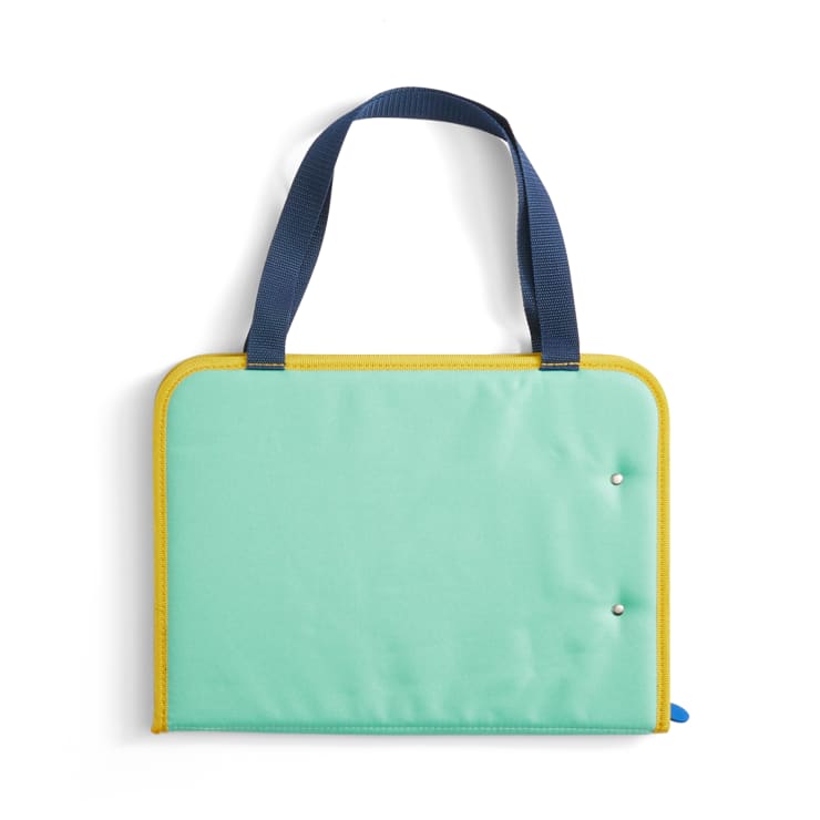 Eine rechteckige mintgrüne Tragetasche mit gelben Verzierungen und zwei marineblauen Griffen. Der Koffer scheint geschlossen zu sein, und zwei Metalldruckknöpfe sind auf der Vorderseite sichtbar.