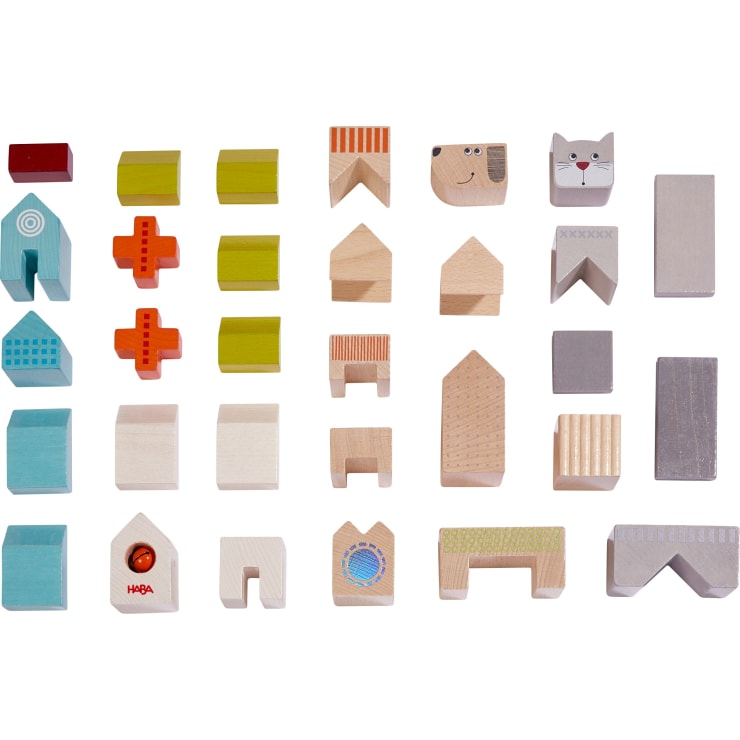 Ein Satz von 25 Holzspielzeugblöcken mit verschiedenen Formen, Farben und Mustern, darunter Häuser, Tiere, geometrische Formen und architektonische Elemente, die in einem Raster auf weißem Hintergrund angeordnet sind.