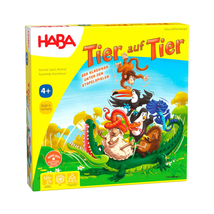 Die Schachtel für das Spiel Tier auf Tier von HABA zeigt Cartoon-Tiere, die auf einem Krokodil gestapelt sind, mit gelbem Hintergrund und grünem Gras. Das Spiel ist für Kinder ab 4 Jahren geeignet.