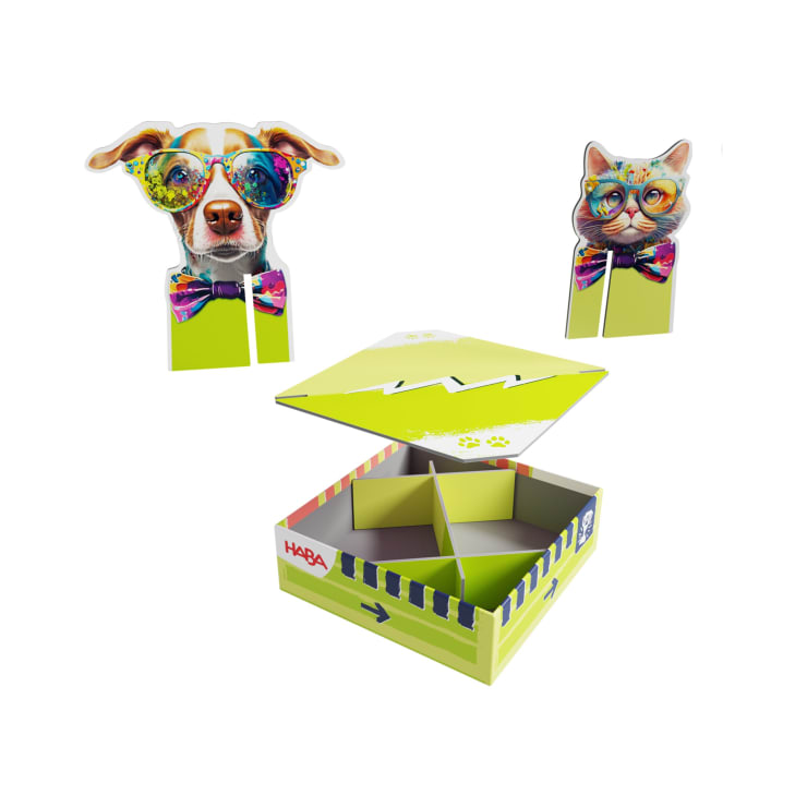 Eine farbenfrohe Spielschachtel mit unterteilten Fächern, einem Deckel mit Zickzack-Muster und zwei Aufstellfiguren, ein Hund und eine Katze mit Brille und Fliege. Die Marke HABA ist auf der Schachtel sichtbar.